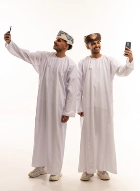 رجال عمانيون باللباس التقليدي يلتقطون صور سيلفي