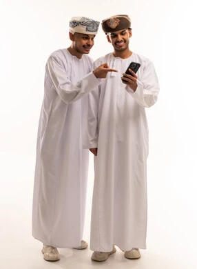 Omani Men in Traditional Dress Using Smartphone