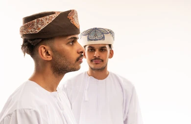 Omani Men in Traditional Dishdasha and Kumma Caps