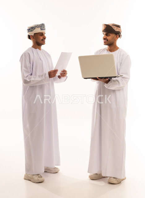 رجال أعمال عمانيون مع كمبيوتر محمول بخلفية بيضاء