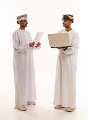 رجال أعمال عمانيون مع كمبيوتر محمول بخلفية بيضاء