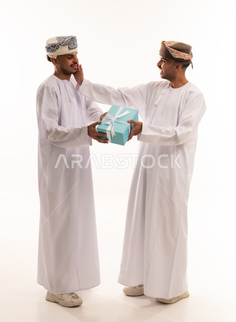 رجلان عمانيان بالزي التقليدي يتبادلان صندوق هدايا