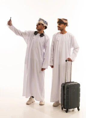 Omani Men in Traditional Dress with Suitcase and Phone