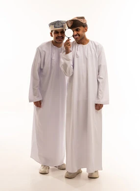 Omani Men in Traditional Dress Using Magnifying Glass