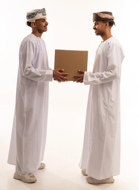 رجال عمانيون يتبادلون صندوق توصيل بخلفية بيضاء