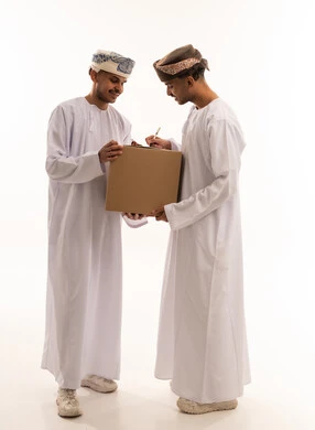 رجال عمانيون يتسلمون طرد شحن على خلفية بيضاء