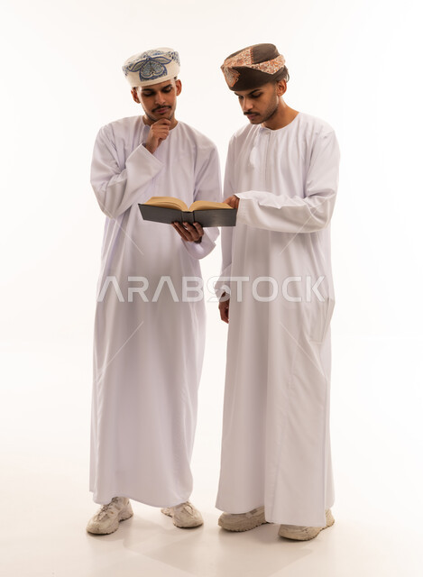 رجلان عمانيان يقرآن كتاباً في الاستوديو