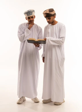 رجلان عمانيان يقرآن كتاباً في الاستوديو