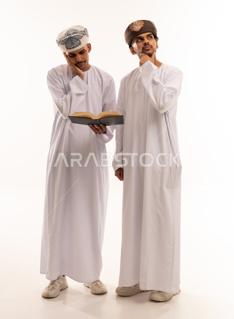 Two Omani Men in Traditional Dress Reading and Thinking