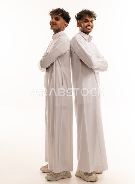 Saudi Men in Traditional Thobes Standing Back to Back