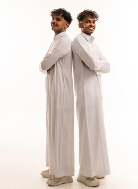 شباب سعوديون بالثوب التقليدي يقفون بظهرين متلاصقين