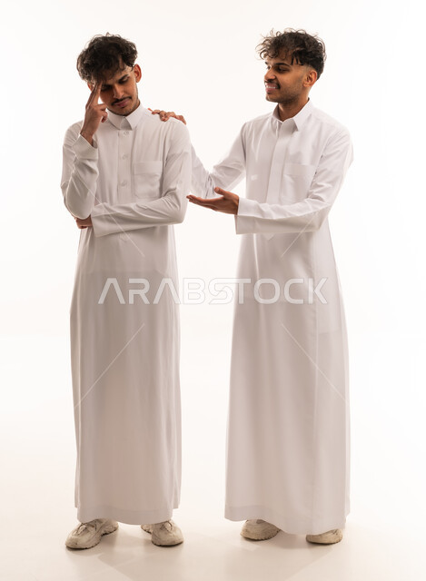 Saudi Men in Traditional Thobes Supporting Stressed Friend