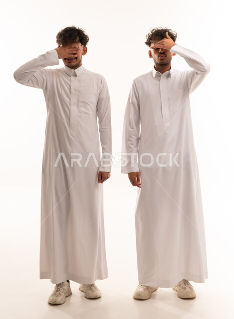 شباب سعوديون بالثوب التقليدي يغطون أعينهم