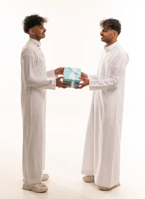Saudi Men in Traditional Thobes Exchanging Gift Box