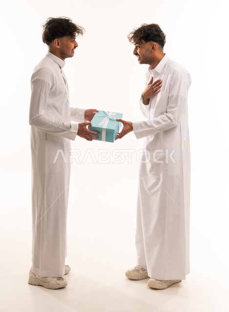 Two Saudi Men Exchanging a Gift on White Background