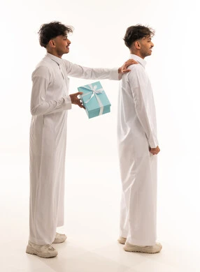 شباب سعوديين بالثوب التقليدي مع علبة هدية