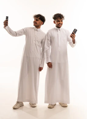Saudi Men in Traditional Thobes Using Smartphones