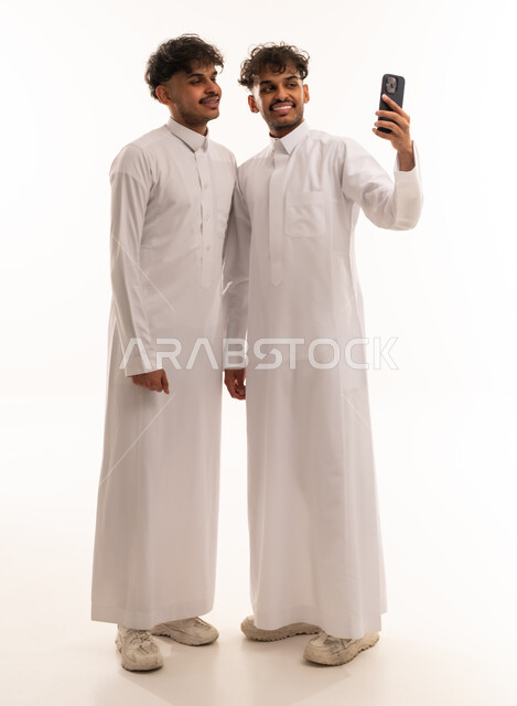 Saudi Men in Traditional Thobes Taking Selfie