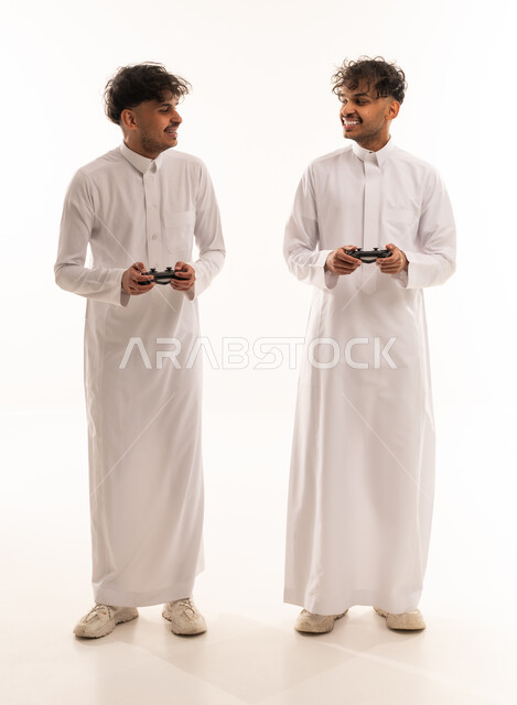 Saudi Men in White Thobes Holding Game Controllers
