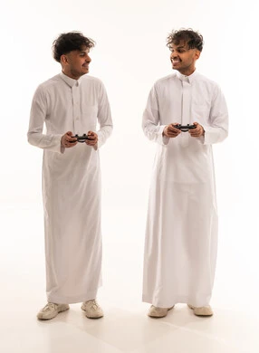 شباب سعوديون بالثياب البيضاء يحملون أجهزة تحكم