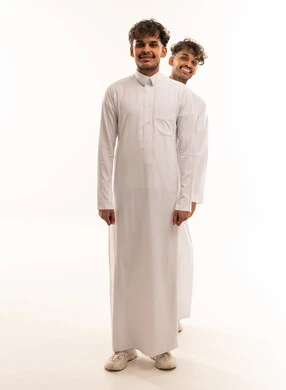 شابان سعوديان بالثوب التقليدي أمام خلفية بيضاء