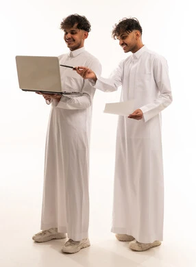 رجال سعوديون يعملون على لابتوب بخلفية بيضاء