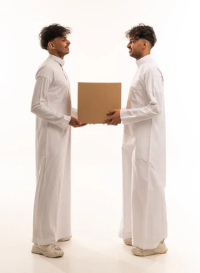 Saudi Men in White Thobes Holding Cardboard Delivery Box