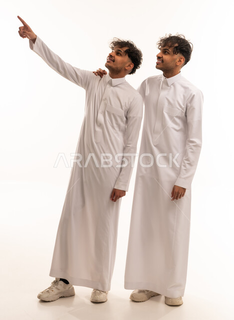 Two Saudi Men in Traditional Thobes Pointing Upward