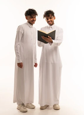 Saudi Men Reading Book in Traditional White Thobe