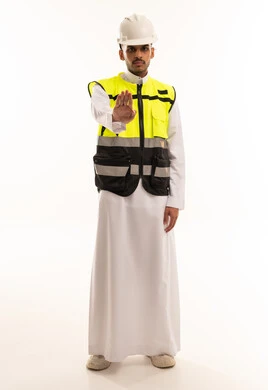 مهندس سعودي بسترة سلامة يقوم بإيماءة التوقف