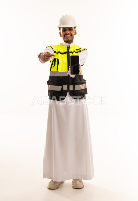 مهندس سعودي يحمل هاتف ذكي بخلفية بيضاء