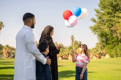 عائلة عربية مع بالونات ملونة في الحديقة عائلة عربية مع بالونات ملونة في الحديقة