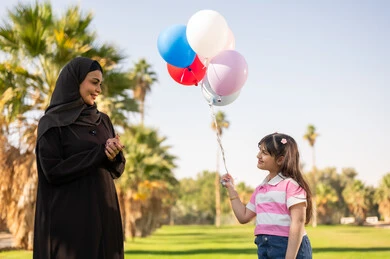 أم سعودية وابنتها مع بالونات في الحديقة أم سعودية وابنتها مع بالونات في الحديقة