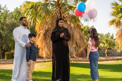 Saudi Family with Balloons in Outdoor Green Park