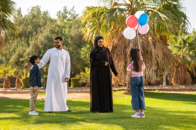 عائلة سعودية في حديقة عامة مع بالونات ملونة