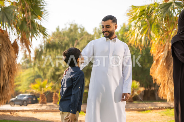 أب سعودي مع ابنه بالثوب التقليدي في الحديقة