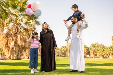 عائلة سعودية في حديقة عامة مع بالونات ملونة