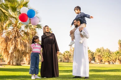 عائلة سعودية في حديقة عامة مع أطفال وبالونات