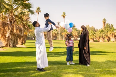 عائلة عربية في حديقة عامة مع بالونات عائلة عربية في حديقة عامة مع بالونات
