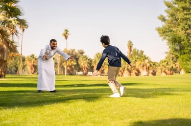 أب سعودي يلعب مع ابنه في حديقة عامة