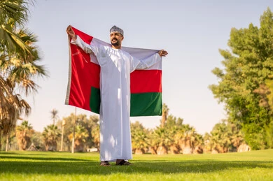 Omani Man Holding Oman Flag in Traditional Dress