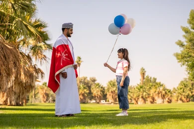Omani Man and Girl with Balloons in Park