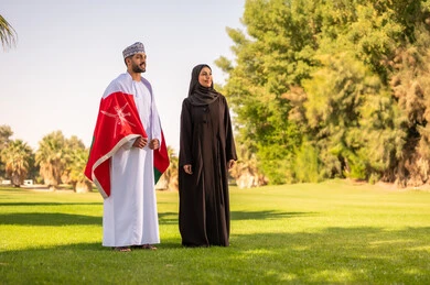Omani Man and Woman with National Flag in Park