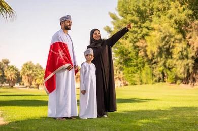 Omani Family with National Flag in Green Park Daylight
