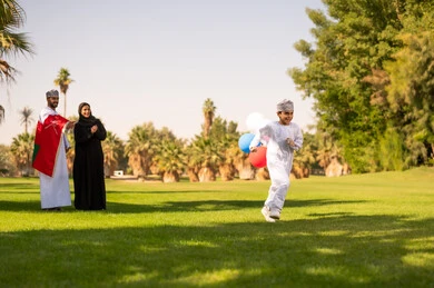 عائلة عمانية تحتفل بالعلم والبالونات في الحديقة عائلة عمانية تحتفل بالعلم والبالونات في الحديقة