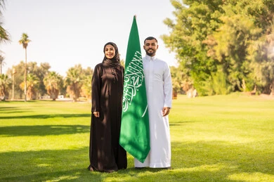 Saudi Man and Woman with National Flag in Park
