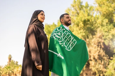 Saudi Couple with National Flag Outdoors