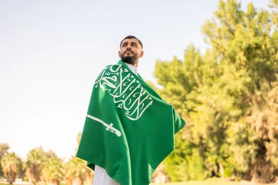 Saudi Man Wearing National Flag Outdoors in Sunlight