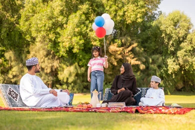 نزهة عائلة عمانية في الحديقة مع بالونات