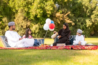 عائلة عمانية في نزهة بالحديقة مع دلة القهوة